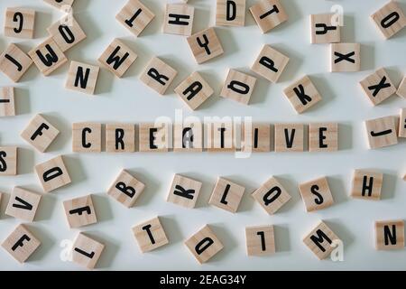 The word creative spelled out in wooden craft letters surrounded by letters.  Concept business, innovation, and ideas. Stock Photo