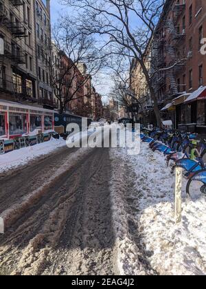 New York, USA - December 12: East Village street in Manhattan covered with pile of snow. Empty winter road with melting snow Stock Photo