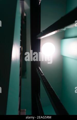 Close-up of handrail on a hallway with stairs. Bright light coming through rails Stock Photo