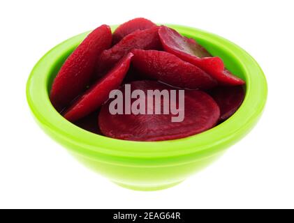 Side view of canned sliced beets in a small green bowl isolated on a white background. Stock Photo
