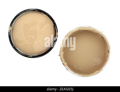 Top view of an open container of beige paint with the lid to the side isolated on a white background.