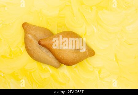 Overhead view of two freshly baked bolillo bread rolls on a yellow painted background. Stock Photo