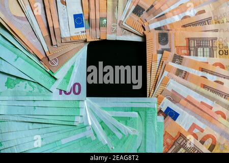 Many hundred and fifty euro bills forming an empty square inside the image. Stock Photo