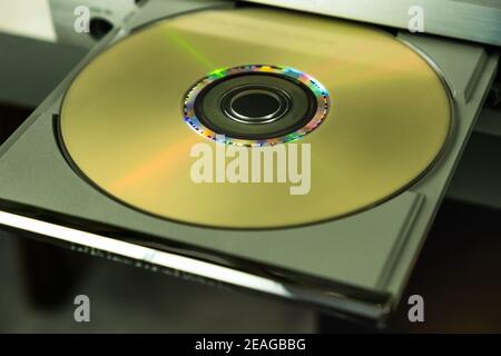 Gold CD on the open tray of the player. Stock Photo