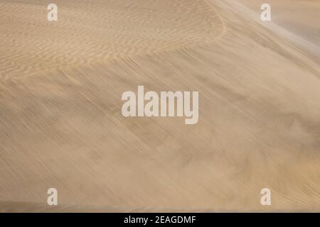 Wind moving the sand and changing the pattern of the desert dunes Stock Photo