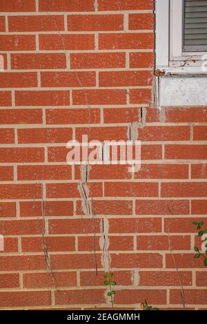 Severe cracked walls on a brick house due to foundation failure Stock Photo