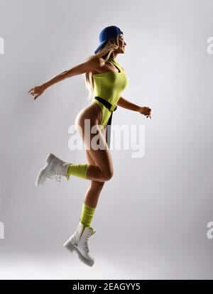 Athletic muscular fitness girl doing exercise jumping running dancing working out on white background. New spring sport workout concep Stock Photo