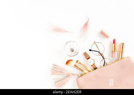Flat lay composition with pink cosmetic bag with cosmetic makeup products, isolated on white background. Flat lay, top view. Stock Photo