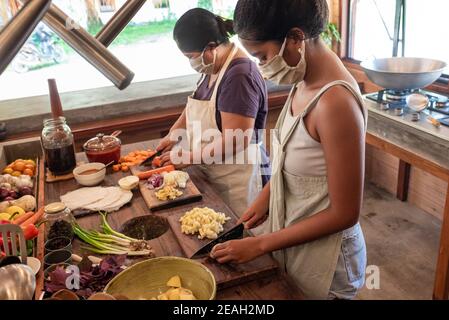 Face Mask Two Asian Female Cooks on Duty Chopping Vegetables Bright Philippine Kitchen Wearing Face Mask and Hair Net Close up Stock Photo