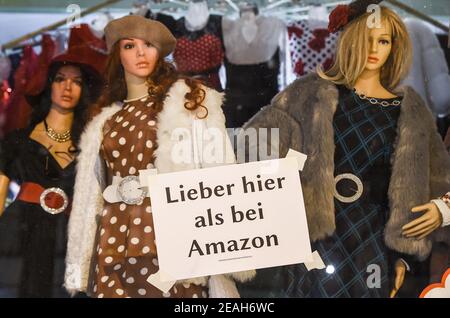 Berlin, Germany. 09th Feb, 2021. On the window of a fashion store in Friedrichshagen Berlin hangs a sign with the inscription 'Better here than at Amazon'. Furthermore, many shops are closed due to the pandemic. Credit: Kira Hofmann/dpa-Zentralbild/dpa/Alamy Live News