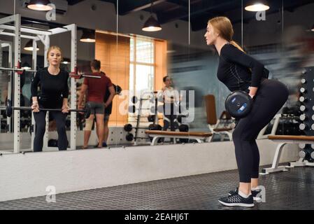 Close up of young fit woman doing barbell exercises in gym. Healthy lifestyle concept. Selective focus Stock Photo