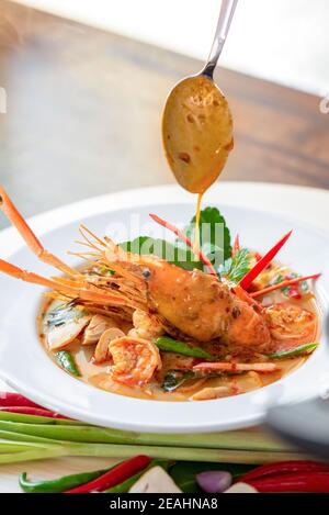 Authentic hot and spicy Tom Yum Kung Thai food with herbs and big prawn in a bowl Stock Photo