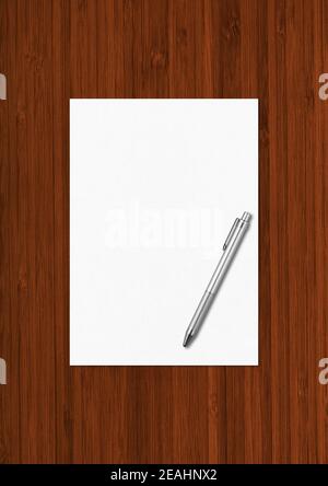 Blank A4 paper sheet and pen mockup template isolated on dark wooden background Stock Photo