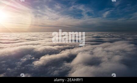Beautiful sunset sky above clouds with dramatic light. Cabin view from airplane Stock Photo