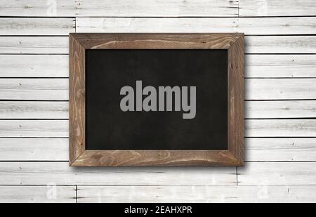 Old rustic black board isolated on a wooden background Stock Photo