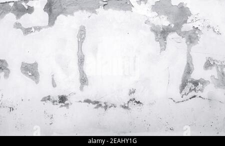 Old white concrete wall are peeling. Painted concrete wall abstract texture background. Deteriorated over time. Cracked cement wall. Empty white wall texture background for minimal life. Stock Photo