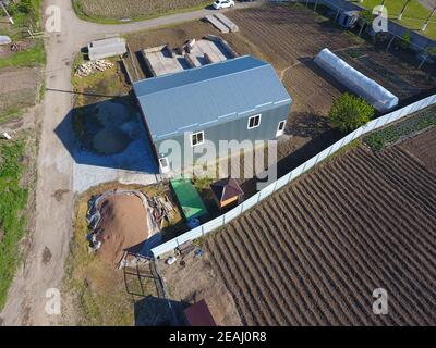 Buildings on the site. Hangar from metal profile, corrugated. The foundation of the house. Stock Photo