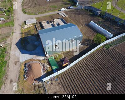 Buildings on the site. Hangar from metal profile, corrugated. The foundation of the house. Stock Photo