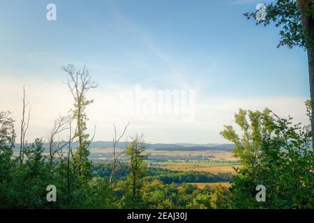 Wonderful view high up from the mountain between the trees of many small villages and fields Stock Photo