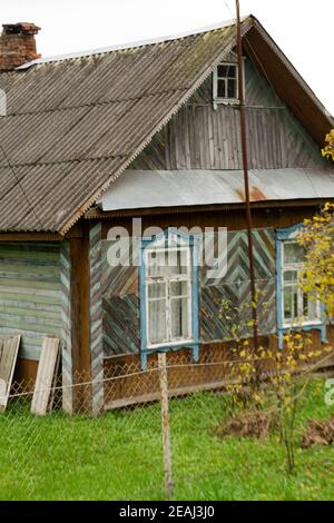 Old traditional wooden house with slate roof in village, Belarus Stock Photo