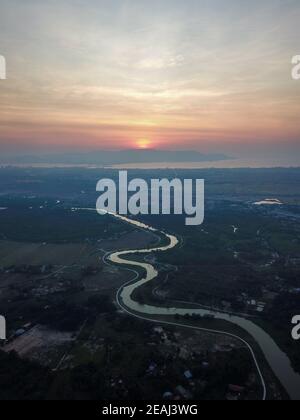 Aerial view river across plantation during sunset Stock Photo