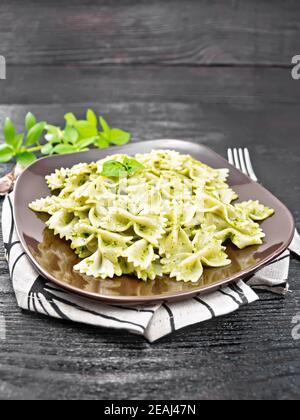 Farfalle with pesto in plate on table Stock Photo