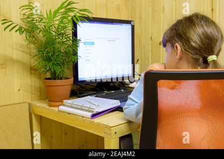A student learns lessons in a computer with online distance learning Stock Photo