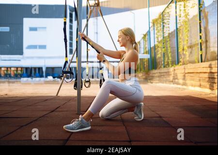 Smiling woman doing stretching exercise outdoors