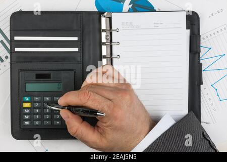 Businessman considers on the calculator Stock Photo