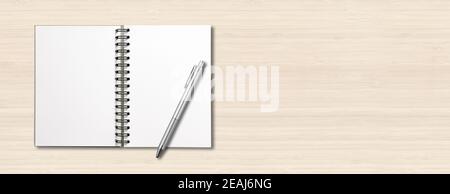 Blank open spiral notebook and pen isolated on white wooden banner Stock Photo