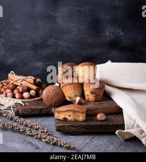 baked muffins with dry fruits and raisins on a brown wooden board ...