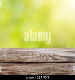 Wood table top on shiny bokeh green background. For product display. Stock Photo