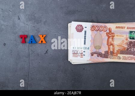 Big stack of Russian money banknotes of five thousand rubles lying on a grey cement background. Stock Photo
