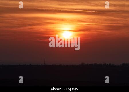 Sunset through cloudy red sky Stock Photo