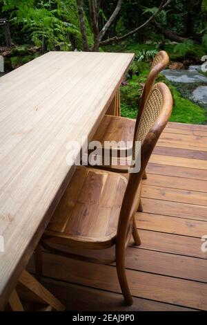 Wooden table and chairs in tropical garden Stock Photo