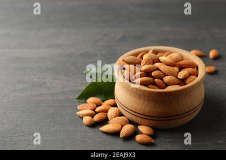 Bowl with tasty almond on gray wooden background Stock Photo