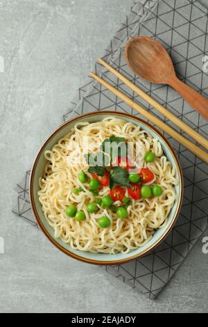 Concept of tasty eating with bowl of noodles on gray background Stock Photo