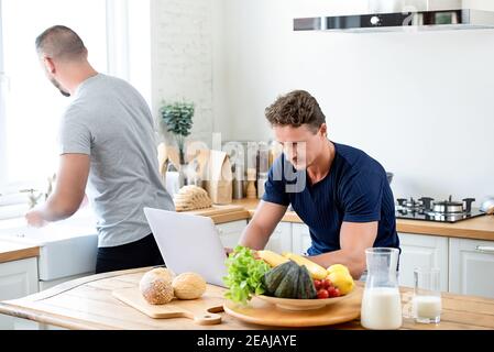 Young gay couple spending morning time together in their kitchen at home Stock Photo