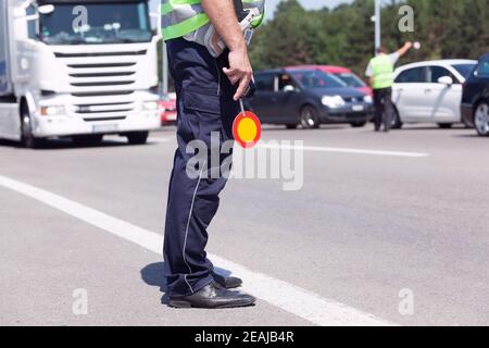 Police officer controlling traffic on the highway Stock Photo