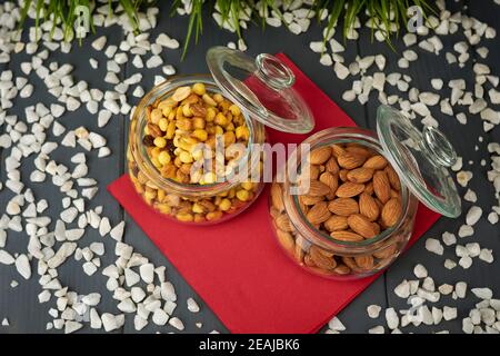 Shelled almonds and mixed nuts in two glass jars. Nutritious snacks Stock Photo
