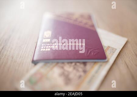 Sweden Passport with a Blurry Fifty Burmese Kyats Bill Partially Inside Stock Photo