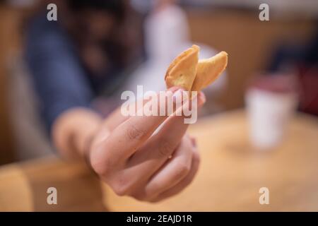 The Hand of a Woman Shows a Furtune Cookie Directly at the Camera Stock Photo