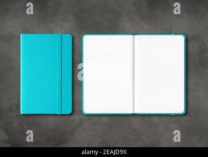 Aqua blue closed and open lined notebooks on dark concrete background Stock Photo