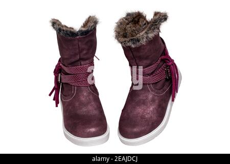 Winter shoes isolated. Close-up of a pair elegant violet suede leather winter boots and lined with brown fur. Girls winter shoe fashion new trends isolated on a white background. Macro photograph. Stock Photo