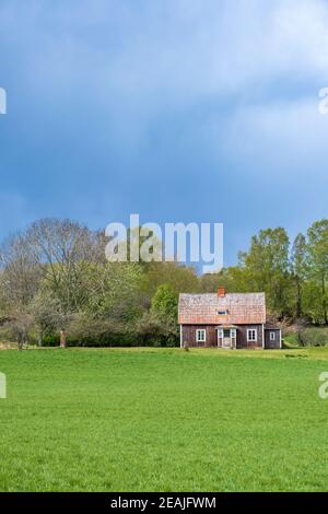 Old abandoned country cottage with dark clouds in the sky Stock Photo