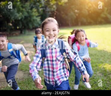 Group of elementary school kids running on the grass Stock Photo