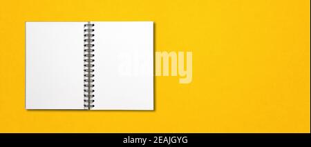 Blank open spiral notebook isolated on yellow banner Stock Photo