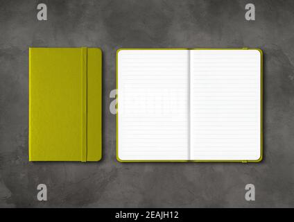 Olive green closed and open lined notebooks on dark concrete background Stock Photo