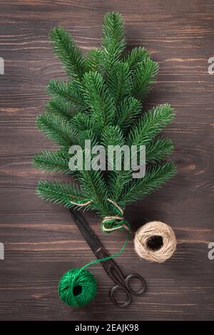 Bouquet of fir branches tied with twine on a wooden table. Stock Photo