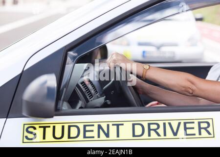 Learner driver holding steering wheel during driving lesson Stock Photo